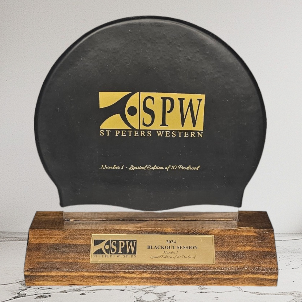 Miklin & Co custom unique award showing mounted swim cap on presentation stand with personalised plaque for elite Australian swimmer recognition and club auction items