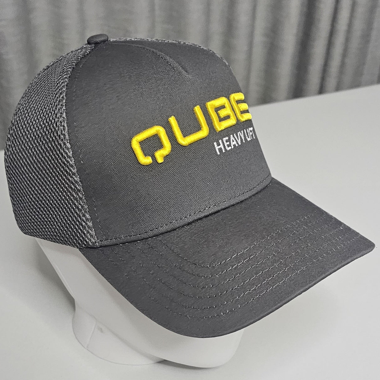 Qube Trucker hat with d embroidery and soft mesh backing that is better for sun safety