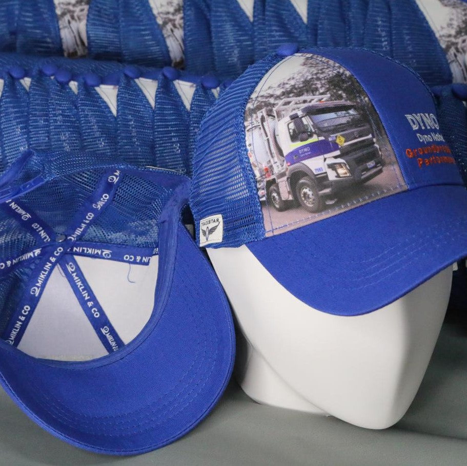 Trucker hat with photo of truck and embroidery logo. Also includes label for branding.