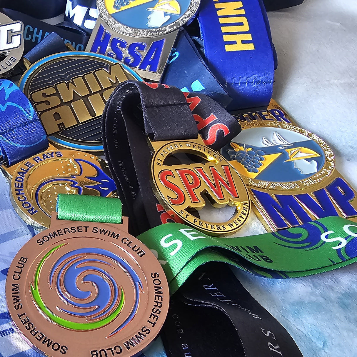 Miklin & Co club level custom medals with team ribbons showing affordable quality awards for local Australian sports clubs and community competitions
